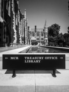 View of Lincoln's Inn Hall in black and white, with signs pointing to the MCR, Treasury Office and Library in the foreground
