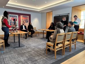A pupil is filmed doing advocacy training in a meeting room at the Inn, watched by trainers