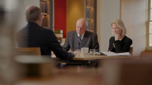 Inner Temple trainers speak across the table to a trainer, shot from behind, in a meeting room at The Inner temple
