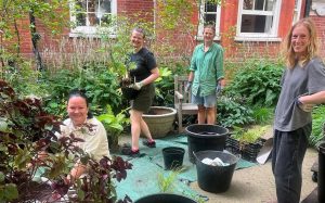 group of 4 people potting up plants