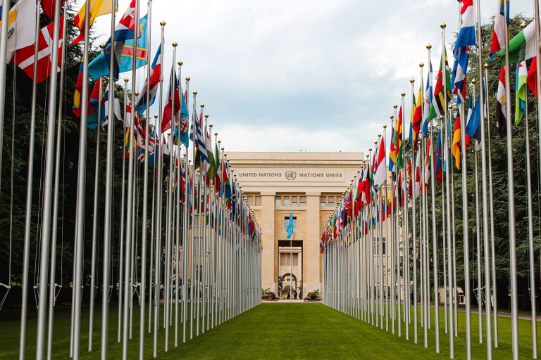 View of the United Nations Office in Geneva adorned with flags of various countries.