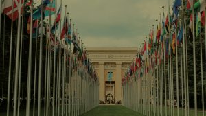 View of the United Nations Office in Geneva adorned with flags of various countries.
